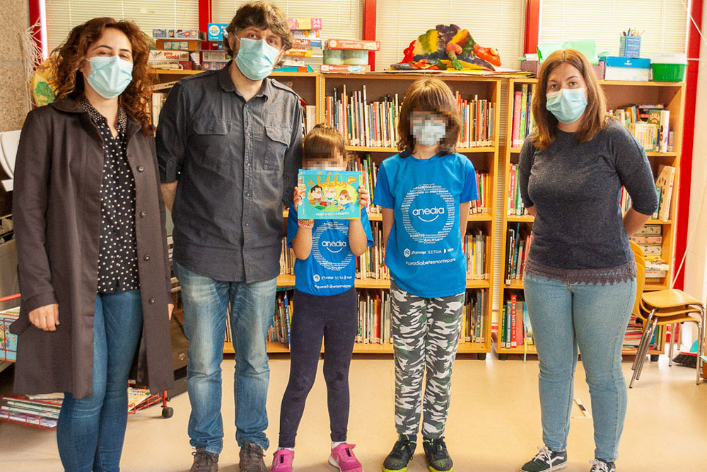 Momento no que Alicia e Martiño entregan os exemplares á biblioteca municipal