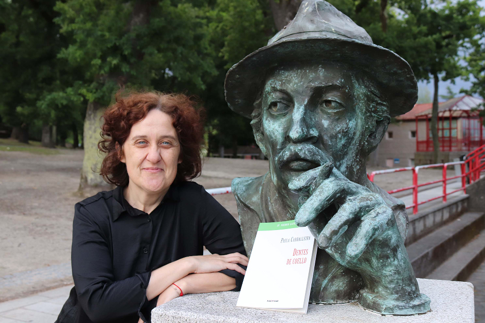 Paula Carballeira pousa xunto ao busto de bronce de Roberto Vidal Bolaño